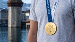 Symbolbild (Athlet, Goldmedaille vor Wasserturm - KI-generiert mit Adobe Firefly)